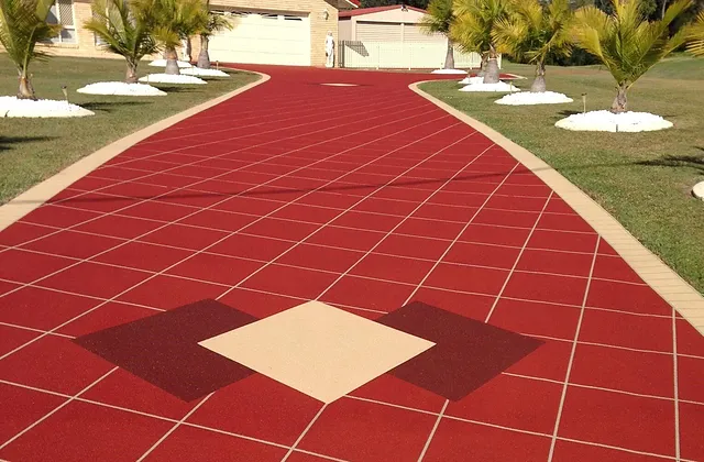 Deep red coloured concrete driveway with a cream and burgundy diamond feature inlay