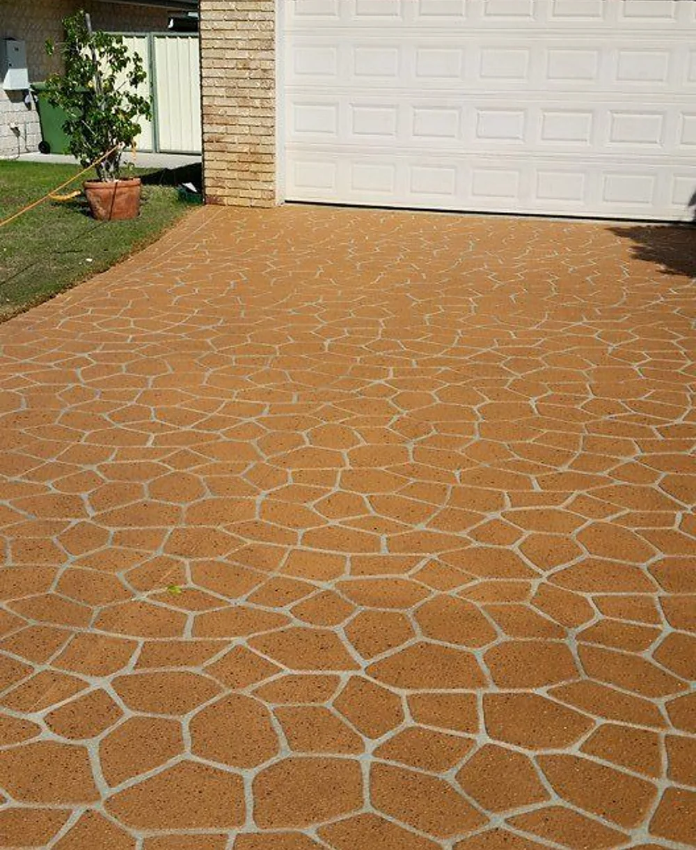 Terracotta stencilled driveway in a random flagstone pattern leading to a double garage